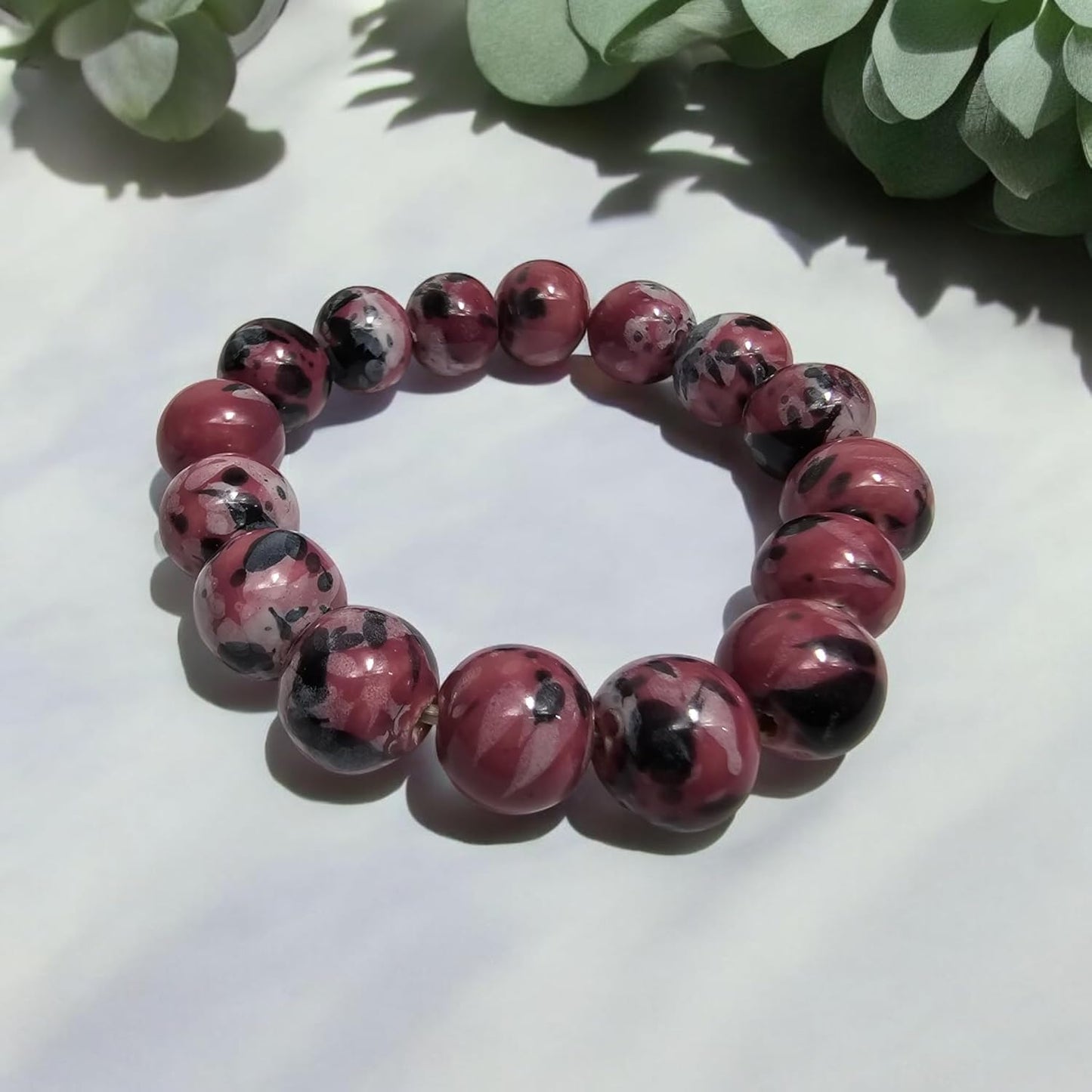 Bracciale con perline in porcellana rosa e decorazioni in bianco e nero